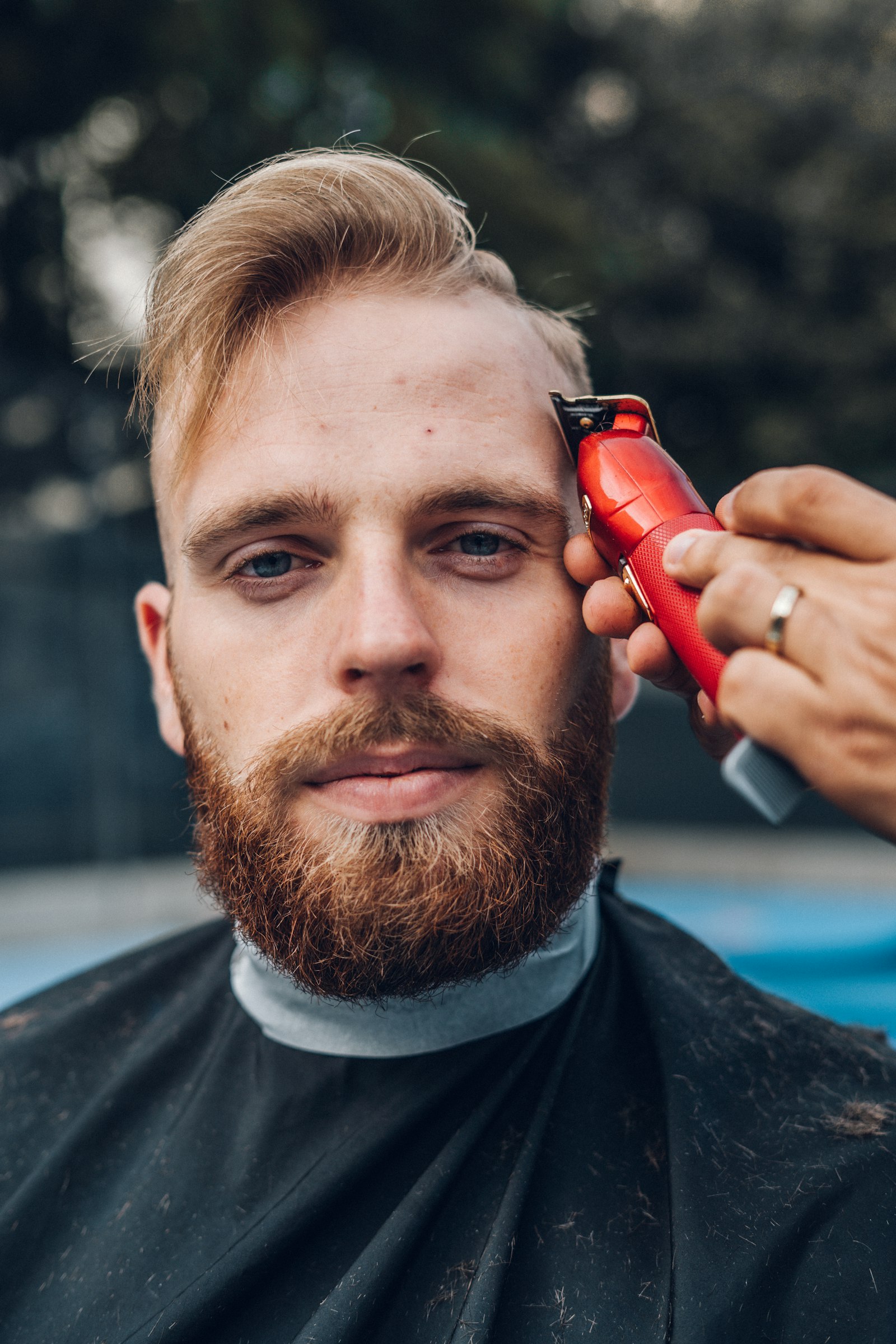 Mann in schwarzem Hemd hält ein rotes und schwarzes Smartphone